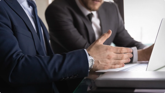 Two Men Talking in Front of a Laptop